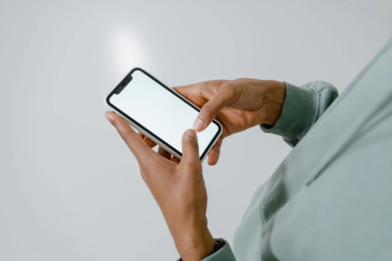 A person holding a phone mid-question, the moment an answer engine is asked for a recommendation.
