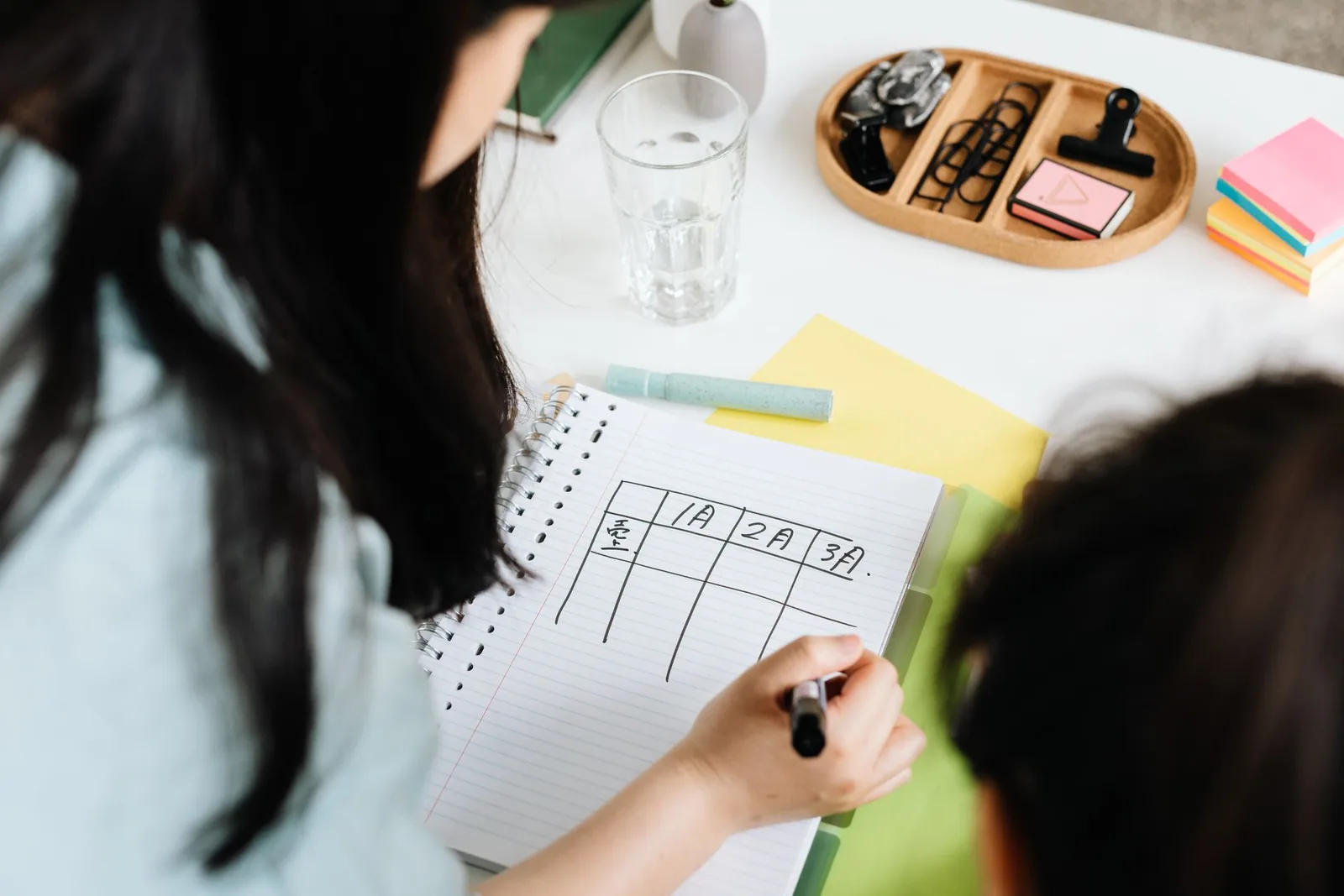 Someone ruling a table in a notebook to plan the work step by step, in the order that moves the number.